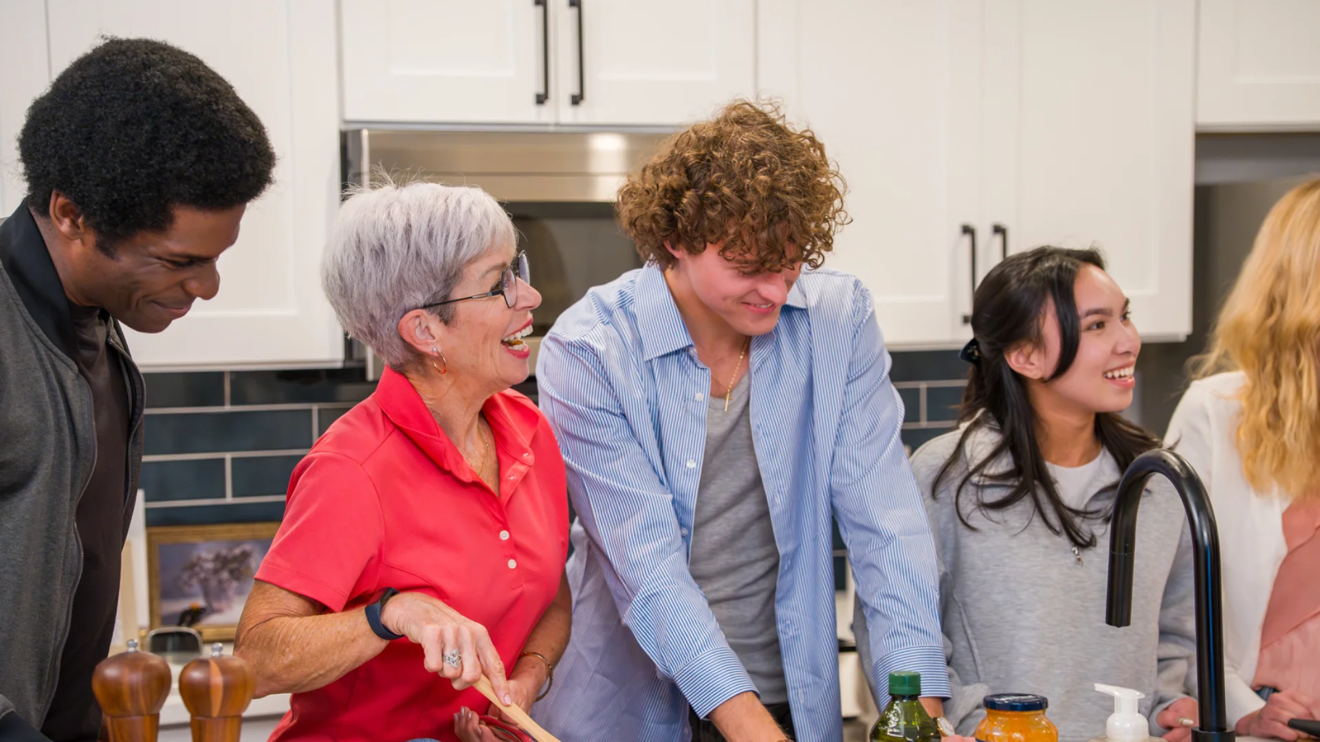 Residents cooking together in a Pointe Grand apartment kitchen